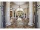 Grand foyer with soaring ceilings, travertine floors with intricate medallion, and stately columns leading to the living area at 6305 E Arabian Way, Paradise Valley, AZ 85253