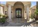 Covered front entrance with stone columns, wrought iron double doors, and decorative accents create curb appeal at 6305 E Arabian Way, Paradise Valley, AZ 85253