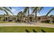 An elegant stucco home with a circular driveway, palm trees, and manicured landscaping provides a grand entrance at 6305 E Arabian Way, Paradise Valley, AZ 85253