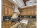 Chef's kitchen featuring custom cabinetry, granite countertops, stainless steel appliances, and a large island with bar seating at 6305 E Arabian Way, Paradise Valley, AZ 85253