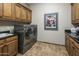 Functional laundry room with stainless steel appliances, tiled floors, and custom cabinets at 6305 E Arabian Way, Paradise Valley, AZ 85253