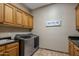 Well-equipped laundry room with wood cabinets and a modern washer and dryer at 6305 E Arabian Way, Paradise Valley, AZ 85253