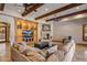 Spacious living room features a fireplace, wood beam ceiling, and custom built-ins for entertainment at 6305 E Arabian Way, Paradise Valley, AZ 85253