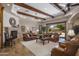 Spacious living room with exposed beam ceilings, stone fireplace, and seamless access to a backyard pool at 6305 E Arabian Way, Paradise Valley, AZ 85253