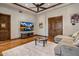 This cozy living room has hardwood floors, a comfy couch, and a large TV at 6305 E Arabian Way, Paradise Valley, AZ 85253