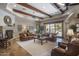 Bright living room featuring a stone fireplace, exposed beam ceilings, and a wall of windows at 6305 E Arabian Way, Paradise Valley, AZ 85253