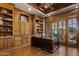 A handsome office featuring hardwood floors, wood ceiling, built-in shelves, and a large desk at 6305 E Arabian Way, Paradise Valley, AZ 85253