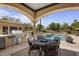 Elegant outdoor dining area featuring a built-in grill, ample seating, and stunning pool views, ideal for entertaining at 6305 E Arabian Way, Paradise Valley, AZ 85253