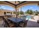 Spacious patio with outdoor dining area, built-in grill, and a serene view of the pool at 6305 E Arabian Way, Paradise Valley, AZ 85253