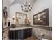Elegant powder room with chandelier, decorative mirror, and patterned tile accents at 6305 E Arabian Way, Paradise Valley, AZ 85253