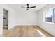 Sun-filled bedroom with hardwood flooring, a ceiling fan, and an ensuite bathroom with a glass-enclosed shower at 6420 S Wilson St, Tempe, AZ 85283