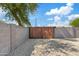 Wooden backyard gate leading to gravel driveway, providing privacy and functionality to the property at 6420 S Wilson St, Tempe, AZ 85283