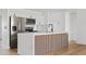Modern kitchen featuring stainless steel appliances, white cabinets, a stylish island, and hardwood flooring at 6420 S Wilson St, Tempe, AZ 85283