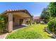 View of a grassy backyard with a covered patio and mature trees at 6758 W Quail Ave, Glendale, AZ 85308
