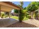 Outdoor patio area with lush landscaping and shade trees at 6758 W Quail Ave, Glendale, AZ 85308
