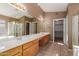 Bathroom featuring a double vanity sink, large mirror, shower, and tile flooring at 6758 W Quail Ave, Glendale, AZ 85308