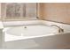 Close-up of bathroom featuring a soaking tub with chrome fixtures and a view to the backyard at 6758 W Quail Ave, Glendale, AZ 85308