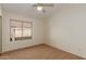 Bedroom with carpet floors, ceiling fan and large window at 6758 W Quail Ave, Glendale, AZ 85308