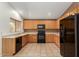Bright kitchen showcasing wooden cabinets, black appliances, and tiled backsplash and flooring at 6758 W Quail Ave, Glendale, AZ 85308