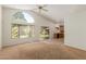 Open-concept living room boasts large windows, a ceiling fan, and seamless flow into the kitchen area at 6758 W Quail Ave, Glendale, AZ 85308