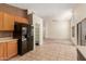View of kitchen featuring wooden cabinets and black appliances with open concept living room at 6758 W Quail Ave, Glendale, AZ 85308
