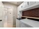 Functional laundry area with a full-size washer and dryer and overhead cabinets for storage at 723 N Joshua Tree Ln, Gilbert, AZ 85234