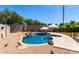 Sparkling backyard pool with a rock waterfall feature, inviting umbrellas and desert landscaping at 723 N Joshua Tree Ln, Gilbert, AZ 85234
