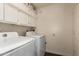Bright laundry room featuring a washer and dryer with built in storage space at 7603 W Oraibi Dr, Glendale, AZ 85308