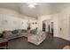Open-concept living room featuring tile floors, neutral walls, and a large comfortable sectional sofa at 7603 W Oraibi Dr, Glendale, AZ 85308