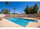 Inviting pool surrounded by palm trees and clear blue sky in backyard at 7603 W Oraibi Dr, Glendale, AZ 85308