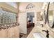 Bathroom features a tiled walk-in shower, a double vanity with granite counters, and a view into the main bedroom at 9559 W Runion Dr, Peoria, AZ 85382