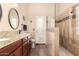 Updated bathroom features a double sink vanity, tiled walk-in shower, and direct access to the outdoors at 9559 W Runion Dr, Peoria, AZ 85382