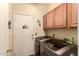 Laundry room features appliances, overhead cabinets, and access to the exterior at 9559 W Runion Dr, Peoria, AZ 85382