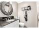 Cozy bathroom featuring a round framed mirror, tile floors, and essential fixtures at 11122 W Desert Butte Dr, Sun City, AZ 85351