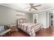 Comfortable bedroom with a ceiling fan, hardwood floors, and ample natural light at 11122 W Desert Butte Dr, Sun City, AZ 85351