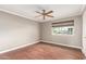 Bedroom with a ceiling fan, wood floor, window with shade, and neutral colored walls at 11122 W Desert Butte Dr, Sun City, AZ 85351