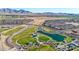 An aerial view of a community park with a pond, playground, and walking paths at 12122 W Levi Dr, Avondale, AZ 85323