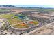 Aerial view of community park featuring baseball fields, lake, playground, and mountain views at 12122 W Levi Dr, Avondale, AZ 85323