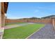 Spacious backyard featuring artificial turf, brick accents, and gravel landscaping at 12122 W Levi Dr, Avondale, AZ 85323