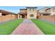 Expansive backyard featuring a brick pathway, lush artificial turf, and decorative rock accents at 12122 W Levi Dr, Avondale, AZ 85323