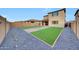 Large backyard with green artificial turf, brick accents, and gravel landscaping at 12122 W Levi Dr, Avondale, AZ 85323