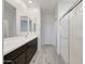 Bright bathroom featuring double vanity, white cabinets, and glass-enclosed shower at 12122 W Levi Dr, Avondale, AZ 85323