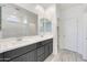 Bathroom featuring double sinks, grey cabinets, large mirrors, and walk-in shower at 12122 W Levi Dr, Avondale, AZ 85323