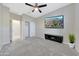 Inviting carpeted bedroom featuring a ceiling fan, closet space, neutral walls, and a modern display screen at 12122 W Levi Dr, Avondale, AZ 85323