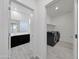 Hallway view into bathroom and laundry area with modern appliances and finishes at 12122 W Levi Dr, Avondale, AZ 85323
