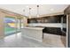 Modern kitchen features dark cabinetry, a kitchen island, pendant lighting, and stainless steel appliances at 12122 W Levi Dr, Avondale, AZ 85323