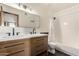 Well-lit bathroom featuring a dual sink vanity and shower with tub at 1353 W Kiowa Ave, Mesa, AZ 85202