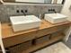 Bathroom vanity featuring double vessel sinks, wood countertop and baskets for storage at 1353 W Kiowa Ave, Mesa, AZ 85202