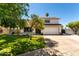 Charming two-story home boasts a well-maintained lawn, mature trees, and a two-car garage at 1353 W Kiowa Ave, Mesa, AZ 85202