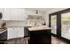 Bright kitchen with white cabinets, stainless appliances, black island, and access to the outdoors at 1353 W Kiowa Ave, Mesa, AZ 85202